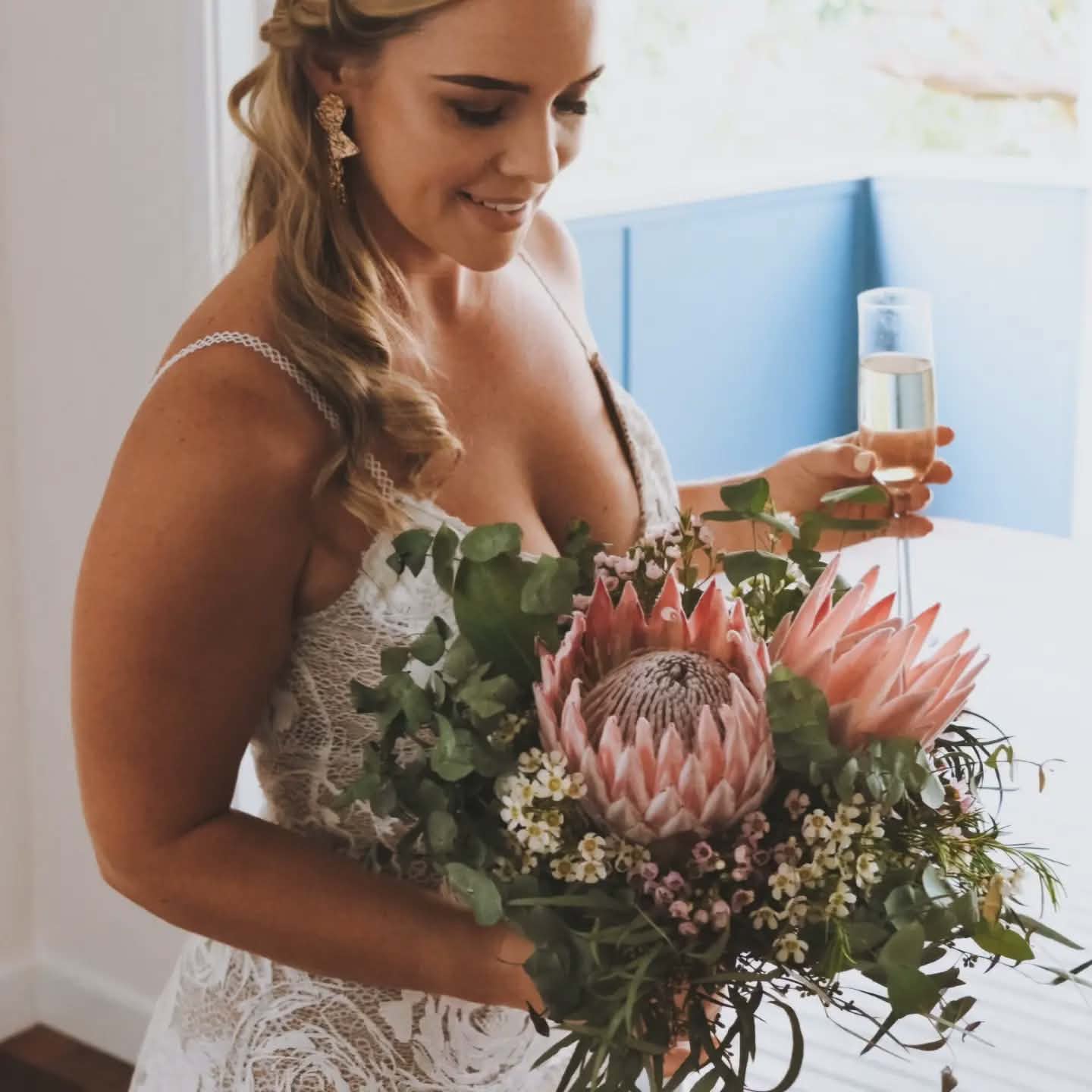 Bride holding a bouquet with protea flowers